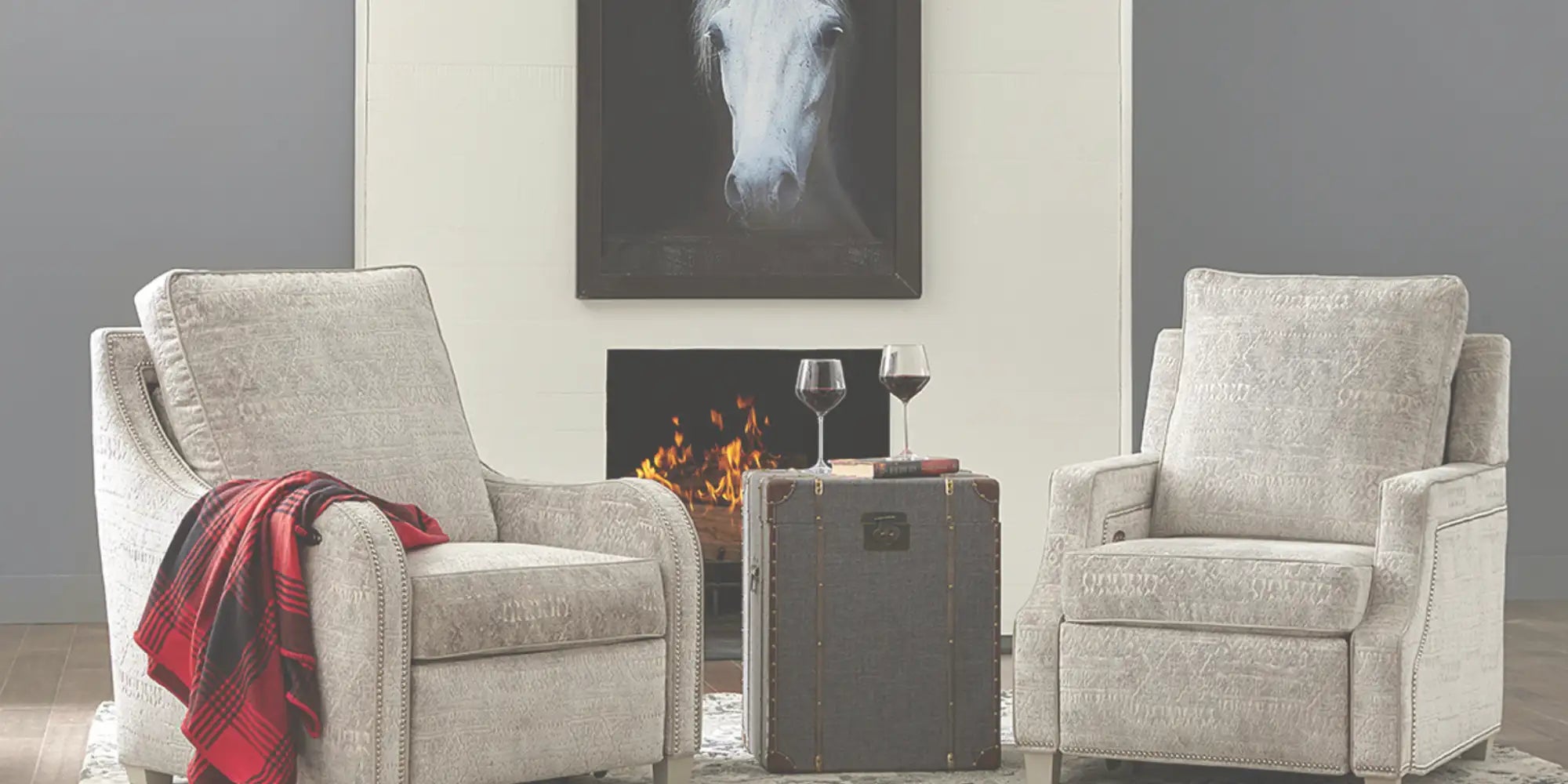 Beige upholstered recliner chairs with subtle textured fabric and decorative nailhead trim.