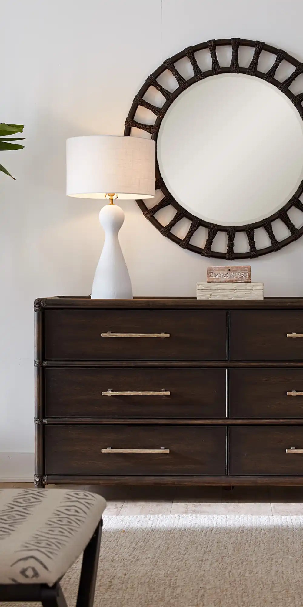 Dark wood dresser with six drawers and gold bar pulls.