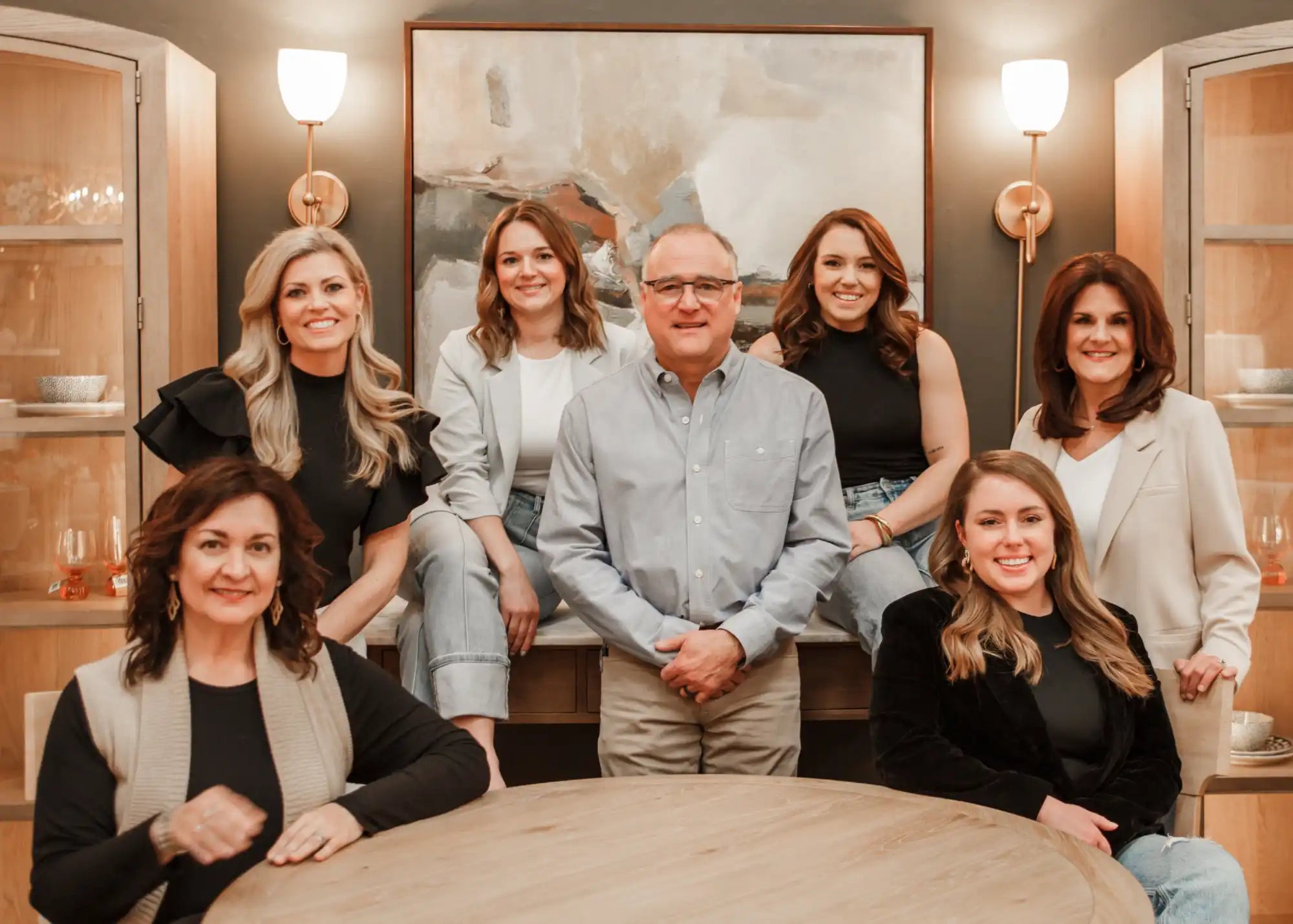 A group of seven smiling people dressed in business casual attire.