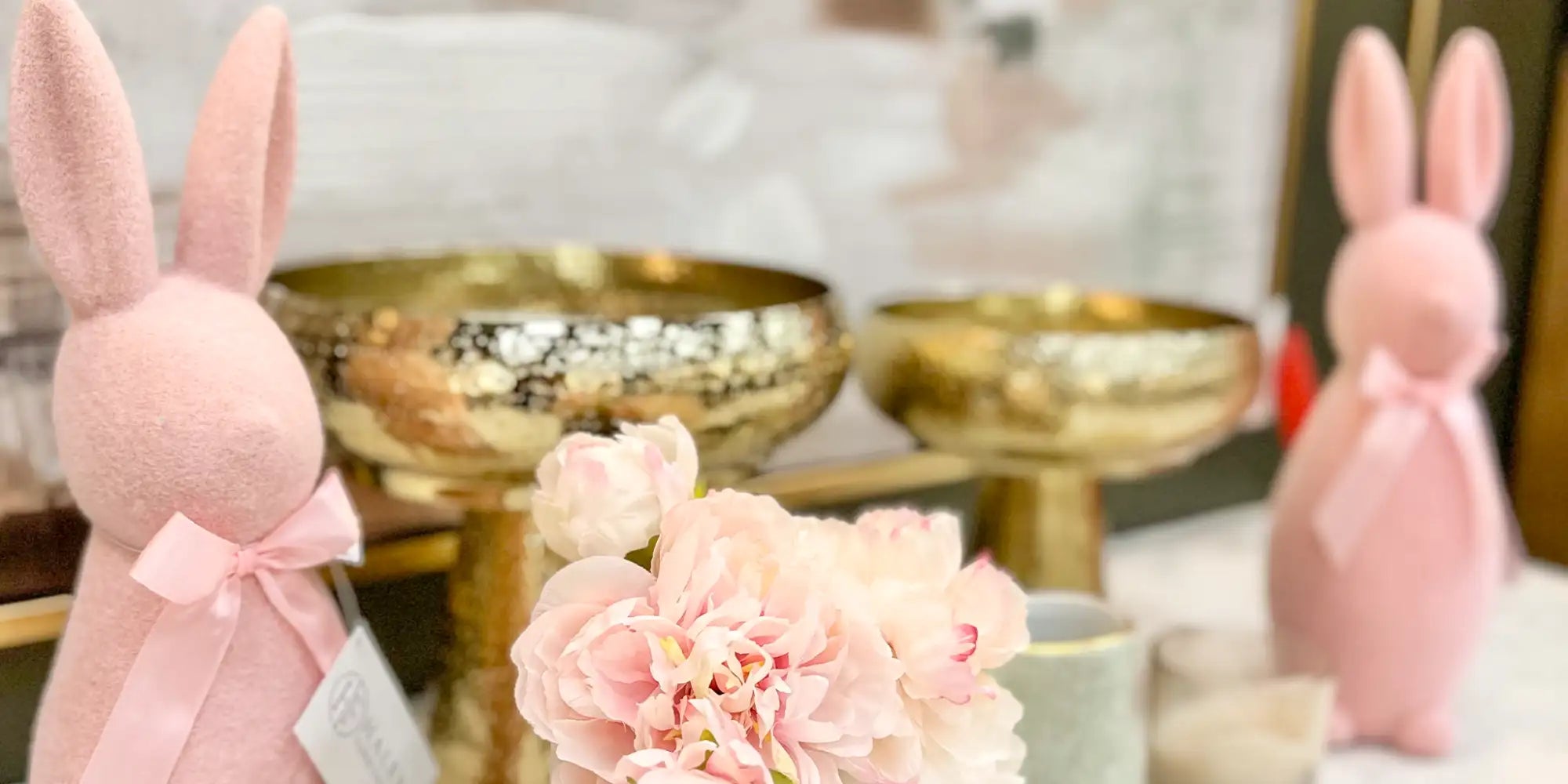 Pink plush bunny figurine with a satin ribbon bow.